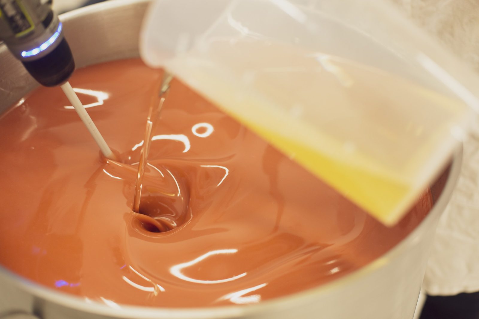 Mélange de la pâte à savon rose dans une cuve